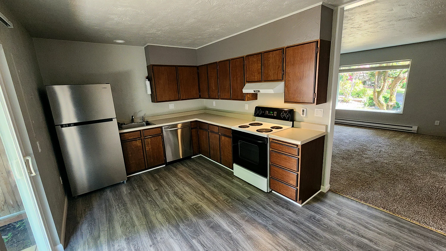 Kitchen with stainless fridge and dishwasher.